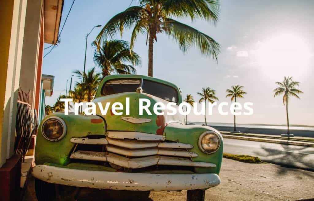 Travel resources featured image of a classic American car in Cuba, by the sea on a bright sunny summer day surrounded by palm trees